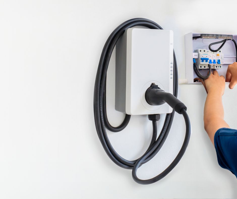 punto de recarga coche eléctrico sobre pared blanca